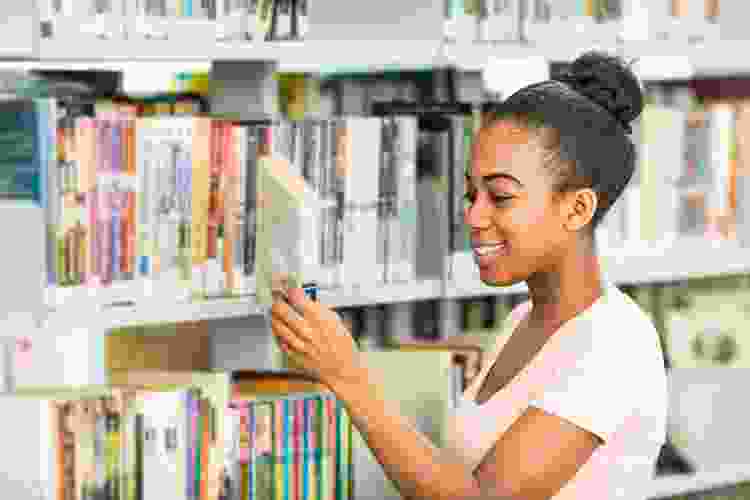 woman flipping through book at the library