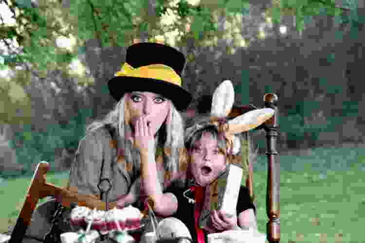 alice and wonderland mad hatter tea party theme with child and mother dressed as mad hatter