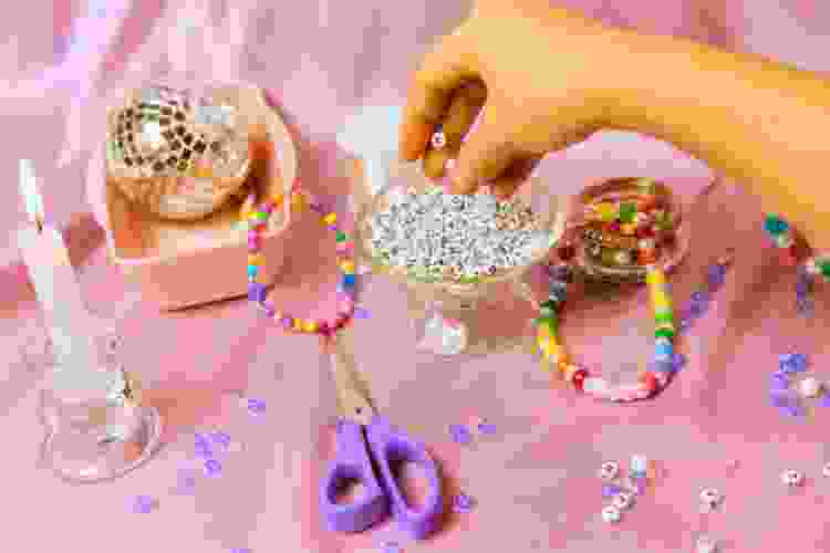 hand reaching for bowl of friendship bracelet beads