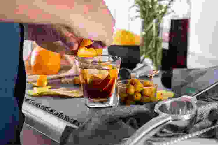 man peeling oranges for cocktail