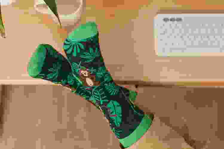 feet wearing socks with monkeys and green leaves on them