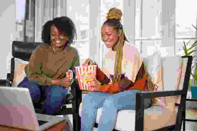 couple watching movie with popcorn at home on the couch