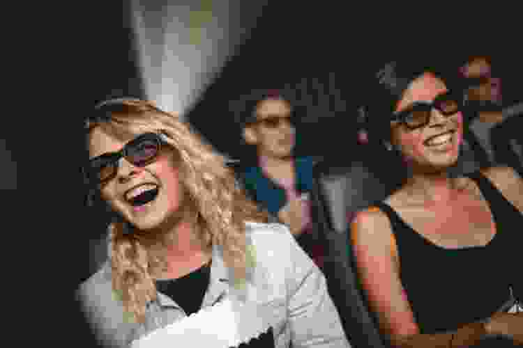 young women watching 3D movie in theater