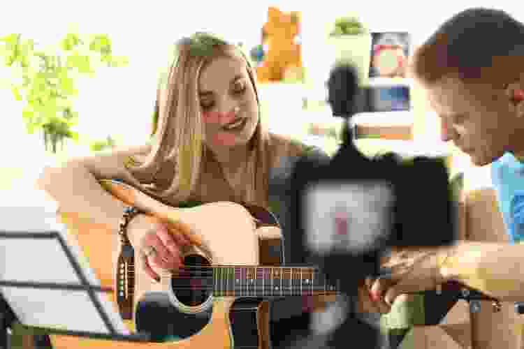 woman being filmed playing guitar