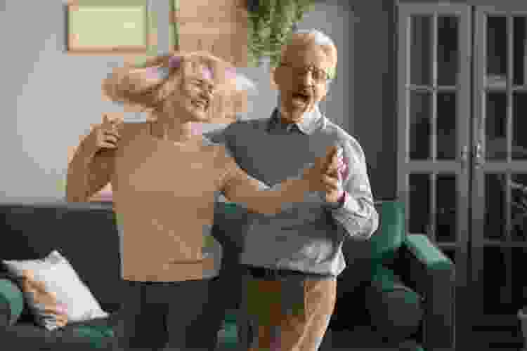 older couple dancing at home together