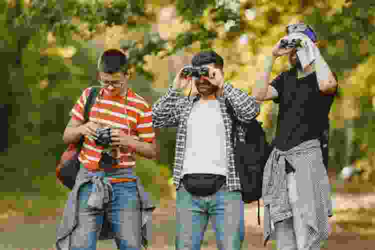 three men exploring nature with binoculars