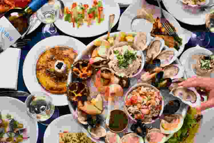 Neptune Oyster table covered in Boston seafood like oysters, lobster, crab claws, etc.