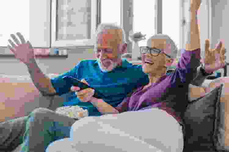 older couple watching tv on the couch