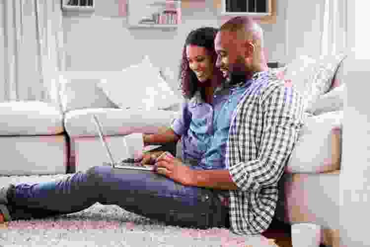 couple playing games on laptop at home