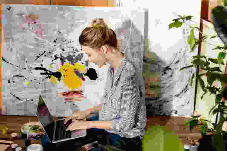 woman on computer while painting