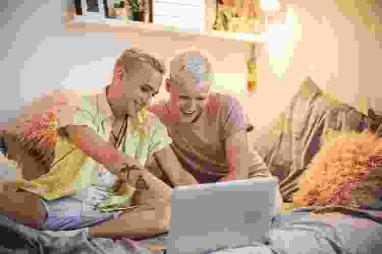 two people watching movie on laptop in bed