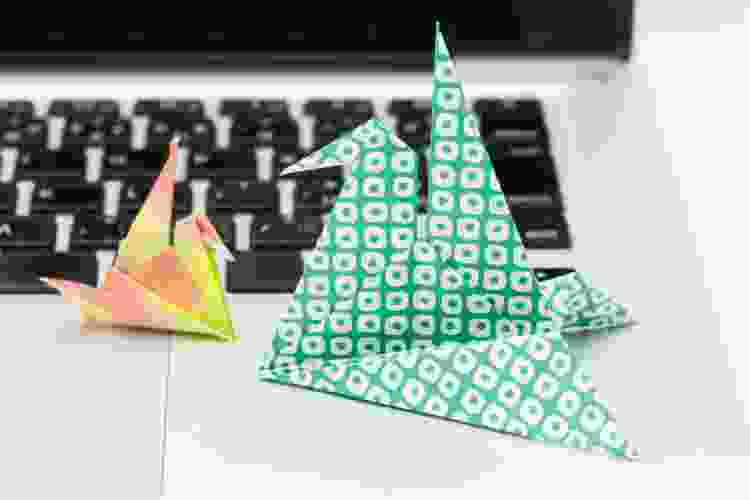 colorful origami birds sitting on laptop