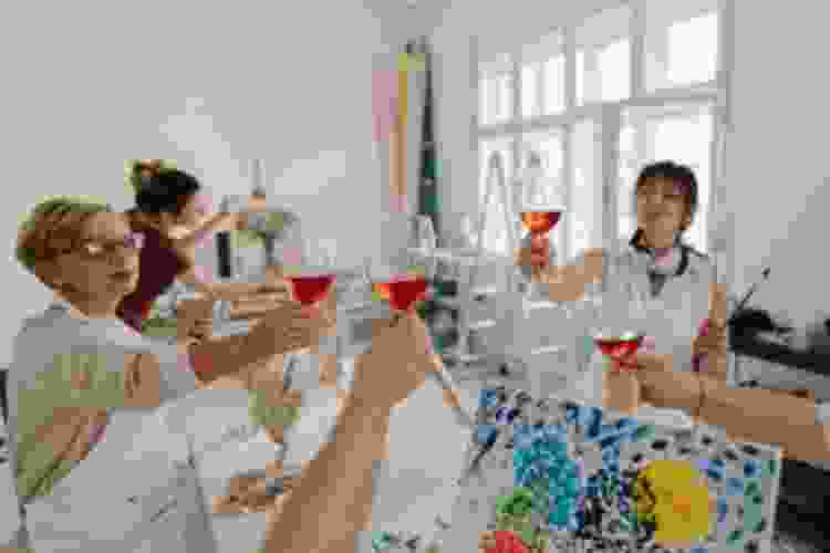 group of women painting and sipping wine