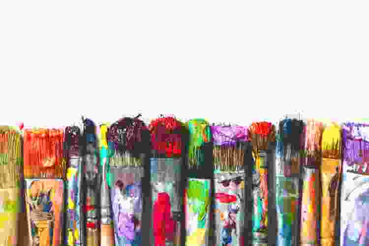 colorful and messy paintbrushes in a row 