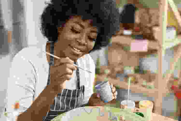 woman painting pottery in pottery studio