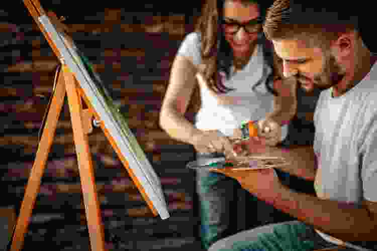 couple painting canvas together