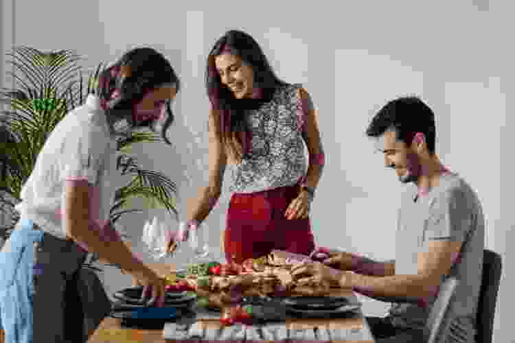 group of people helping set the table for a dinner party