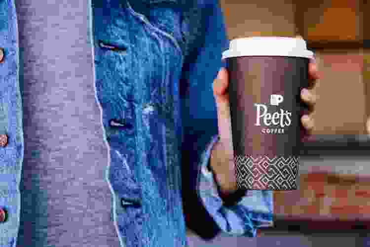 hand holding cup of Peet's Coffee