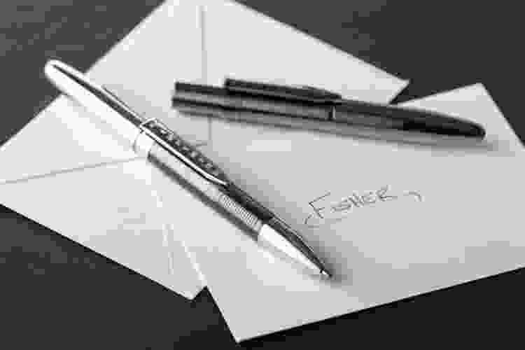 Fisher space pens sitting on blank envelopes