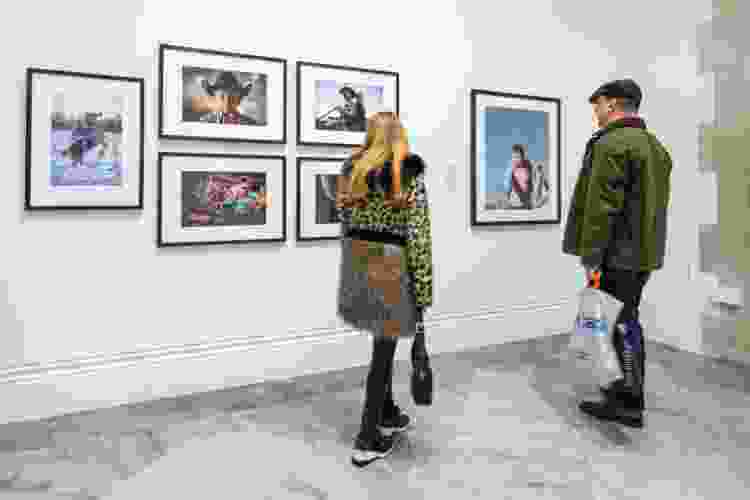 People admiring a portrait photography exhibition