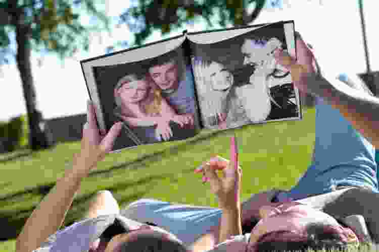 couple in park looking at photo book