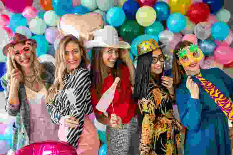 friends posing with props in photo booth