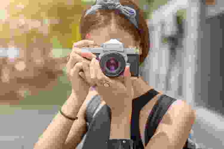 young woman holding film camera