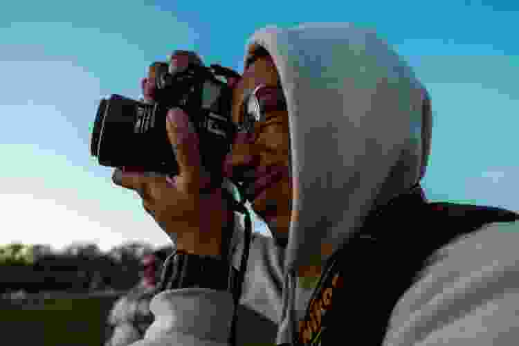 young man taking photos at dusk