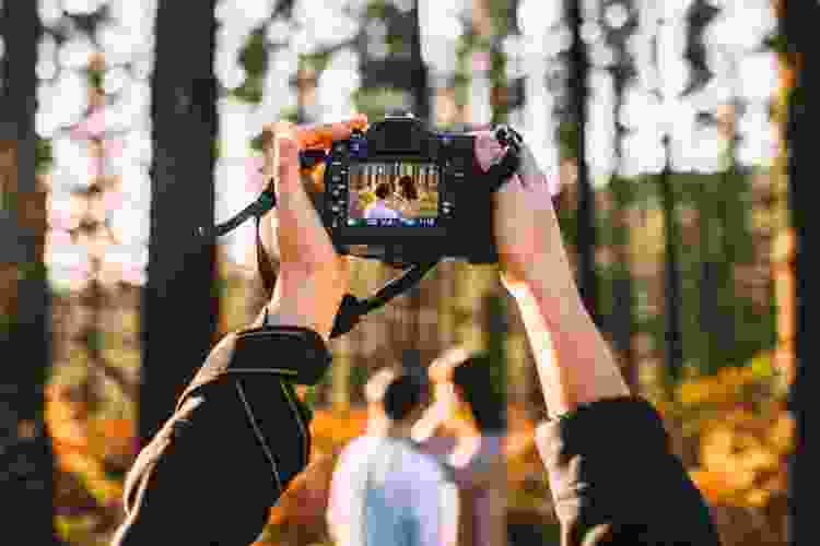 photographer pointing camera toward couple