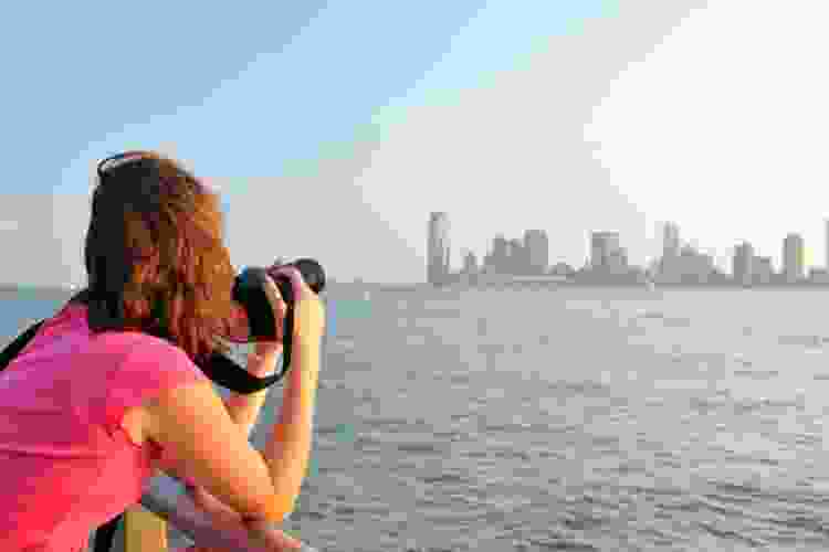 woman taking photo of New York City skyline