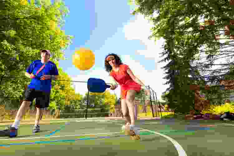 couple playing pickeball outdoors