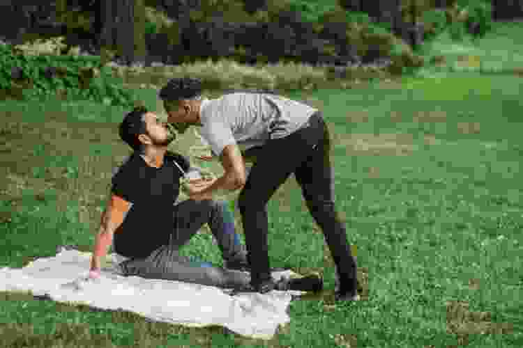 couple kissing on picnic blanket