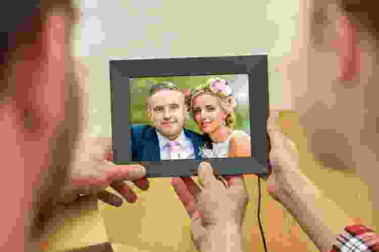 couple holding digital picture frame