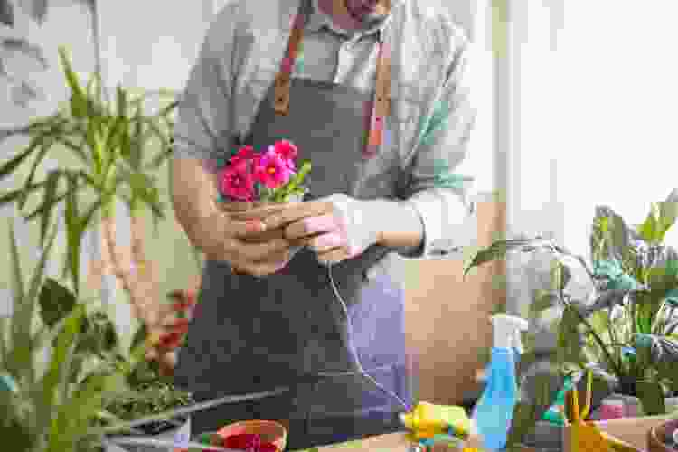 man assembling pink flowers 