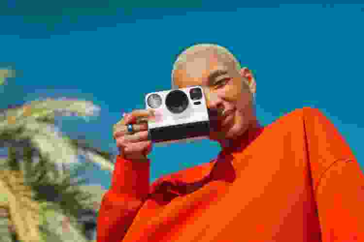 woman taking photo with vintage Polaroid camera