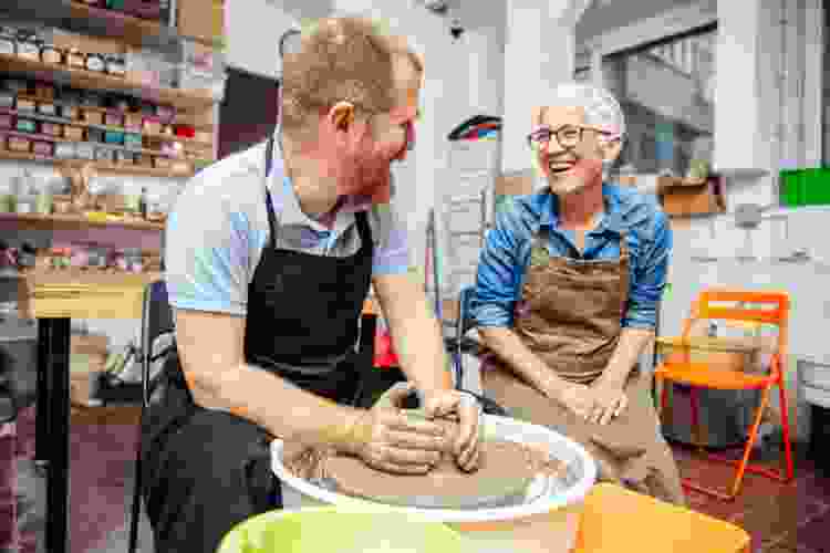 two people molding clay in pottery class