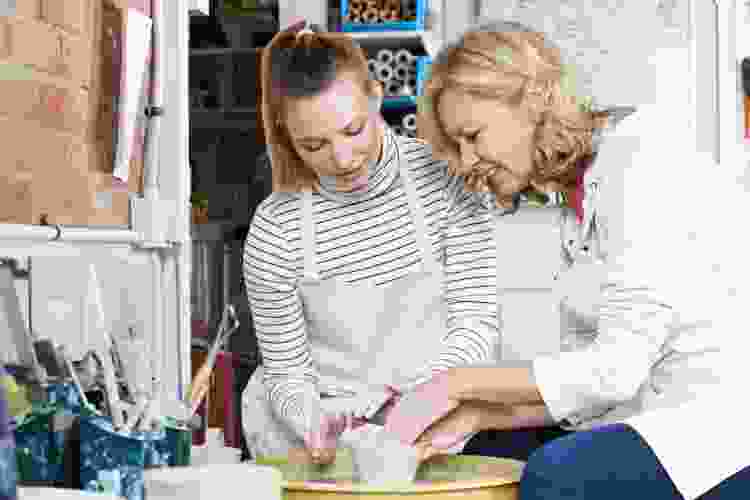 mom and daughter molding clay in pottery class