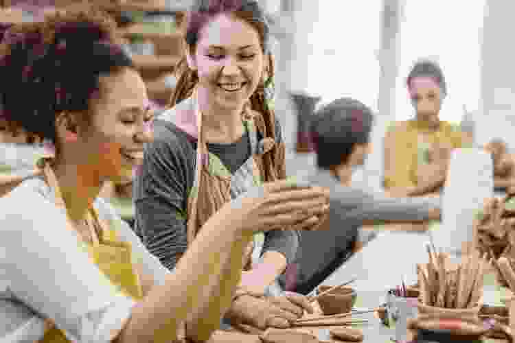 young women molding clay in pottery class