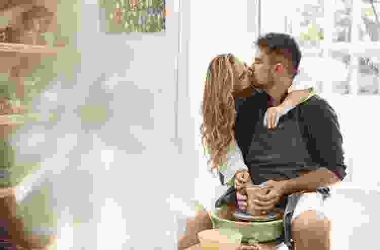 couple kissing in pottery studio