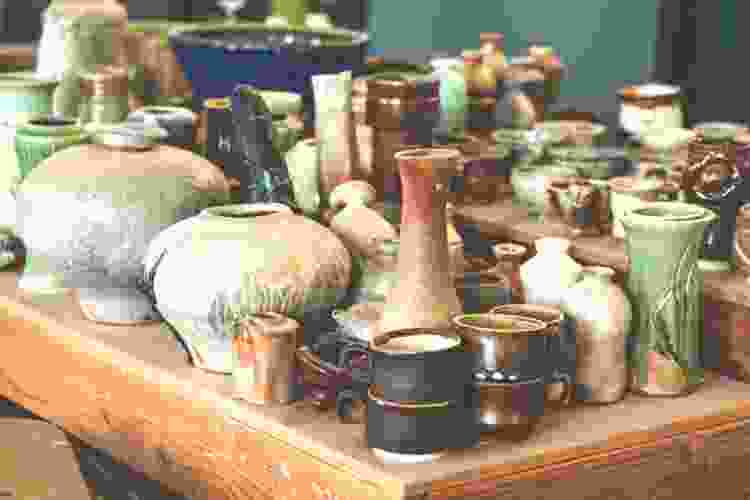 a table filled with different shapes and colors of pottery