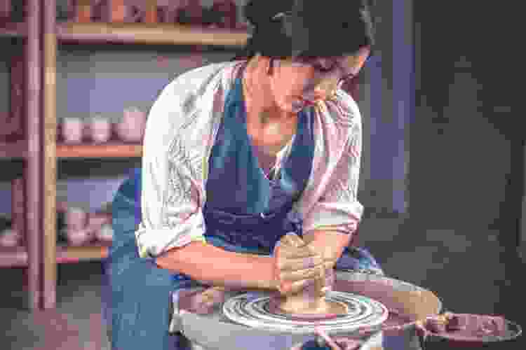 woman making pottery with a potter's wheel