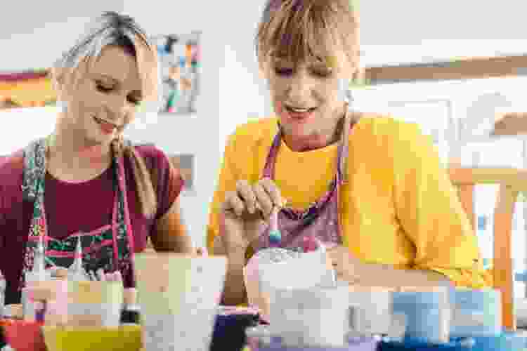 mother and daughter painting pottery together