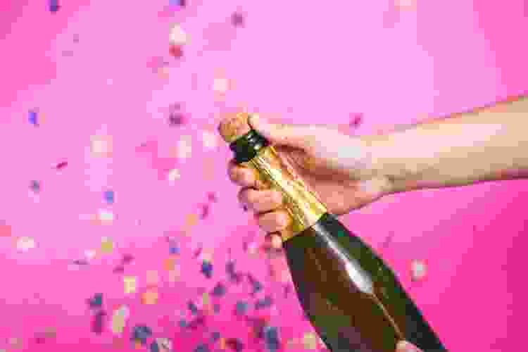 giant bottle of champagne and pink confetti