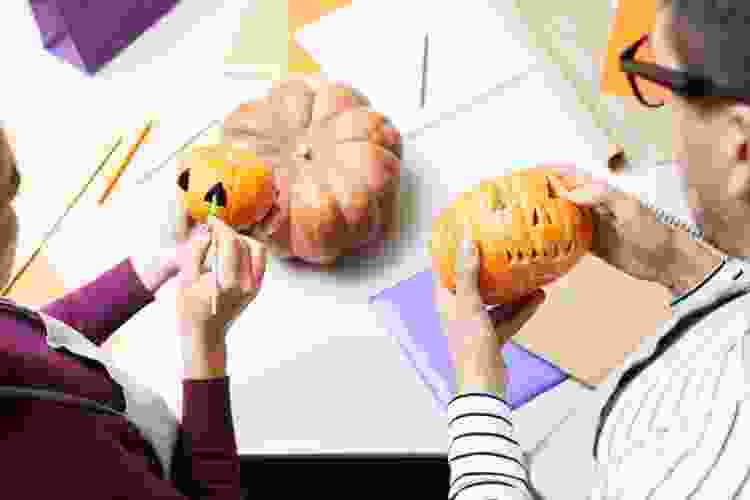 couple painting and carving pumpkins