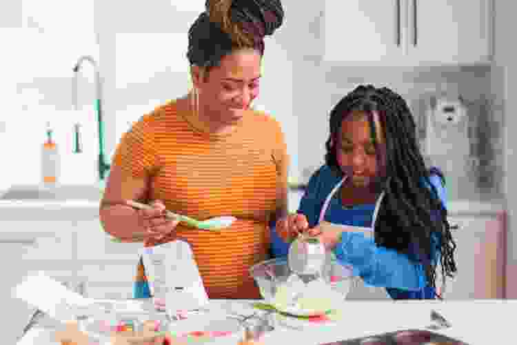 mother and daughter baking cookies at home