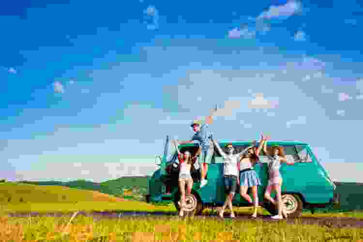 group of young people in van on road trip