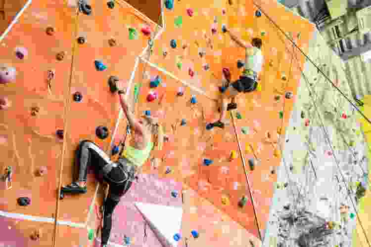 two young people climbing on indoor rock wall