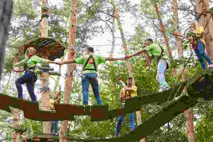 team of people working together in ropes course