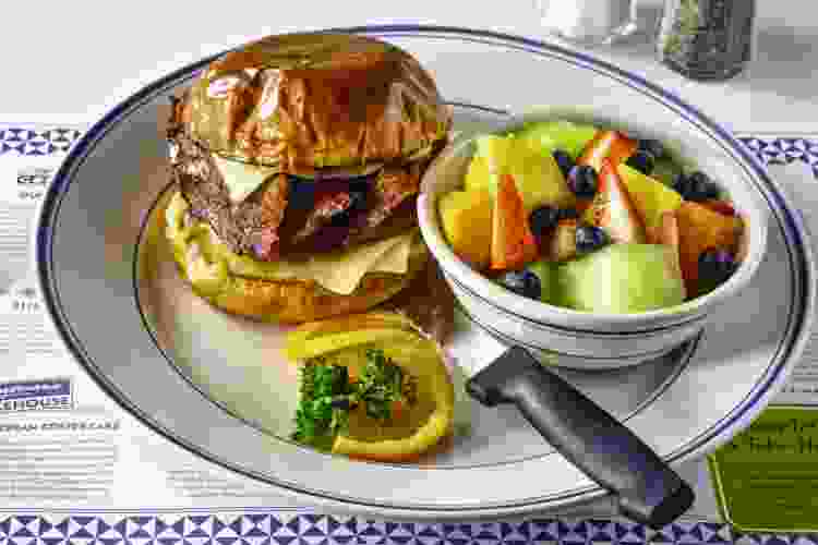 plate of breakfast burger and fruit