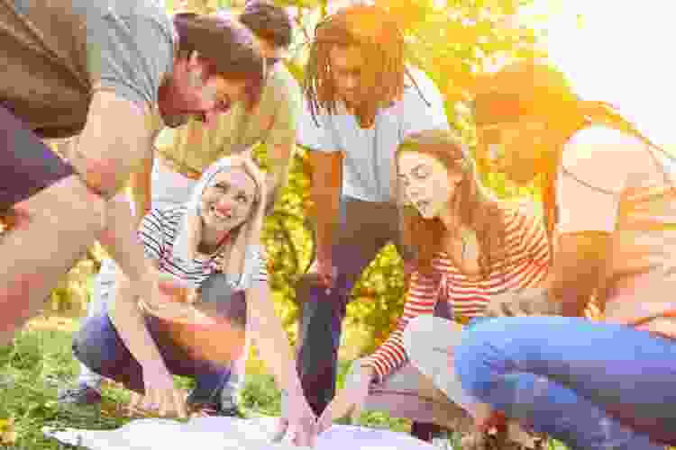 group of friends reading map in the park